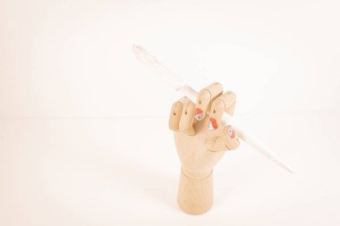 Beyaz arka planda beyaz bir boya fırçası tutan tahta el..