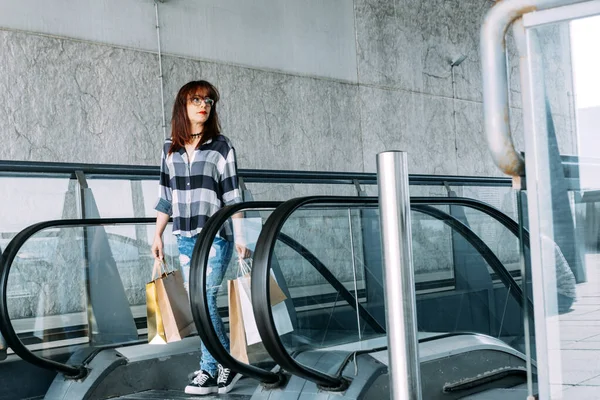 Mujer Con Bolsas Subiendo Una Escalera Mecánica —  Fotos de Stock