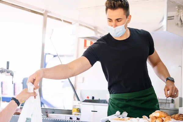 Yemek kamyonu konsepti. Yemek siparişini müşteriye veren aşçı..