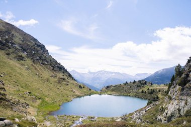 Mavi gökyüzü ile dağların arasında mavi gölü olan manzara.