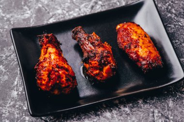 Siyah tabakta kızarmış tavuk porsiyonları..