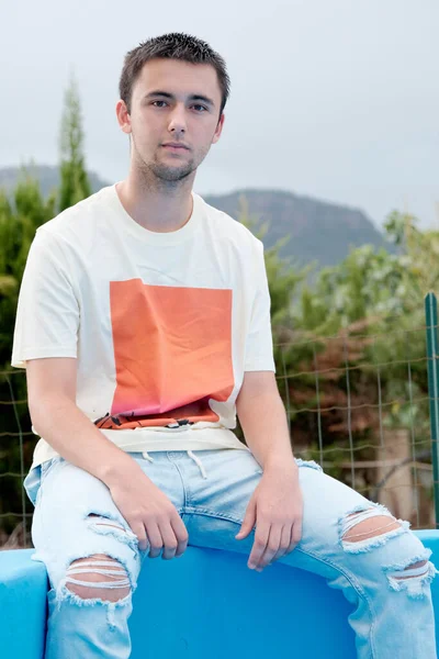 Adolescent Assis Sur Bord Une Piscine Sans Eau Images De Stock Libres De Droits