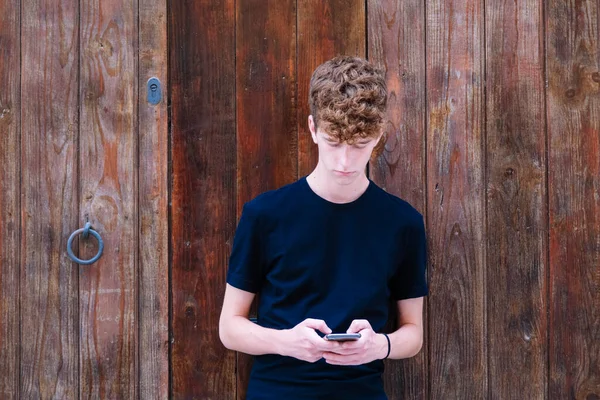 Adolescente Chico Con Pelo Rizado Mirando Teléfono —  Fotos de Stock
