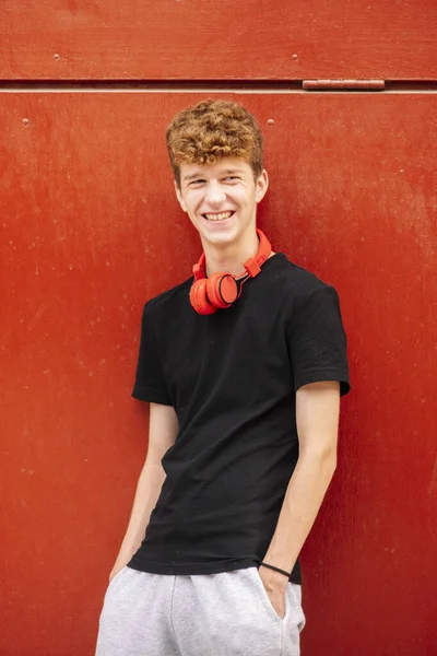Adolescente Chico Con Auriculares Con Fondo Rojo —  Fotos de Stock