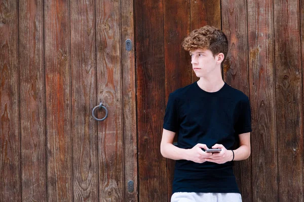 Adolescente Chico Con Pelo Rizado Mirando Teléfono —  Fotos de Stock