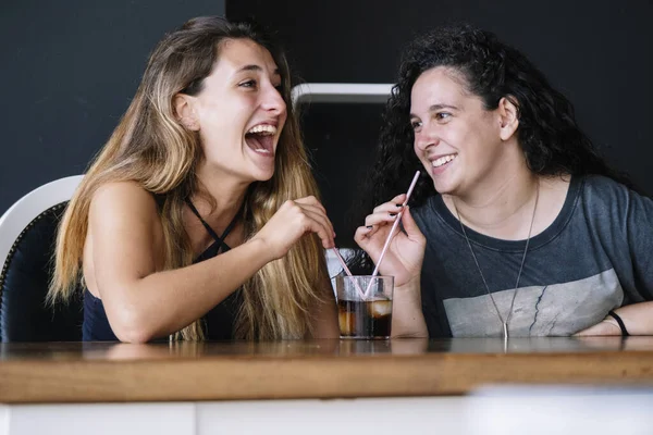 Dos Chicas Compartiendo Trago Riendo —  Fotos de Stock