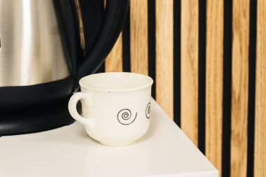 Masanın kenarında küçük beyaz bir fincan kahve..