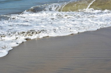 Beyaz köpüklü doğal deniz dalgaları Coxs Bazar, Bangladeş 'te kumlu sahilde süzülüyor. Seyahat, yaz, doğa, deniz yaşamı, kıyı geçmişi ve rahatlama kavramları için mükemmel..