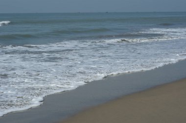 Beyaz köpüklü doğal deniz dalgaları Coxs Bazar, Bangladeş 'te kumlu sahilde süzülüyor. Seyahat, yaz, doğa, deniz yaşamı, kıyı geçmişi ve rahatlama kavramları için mükemmel..