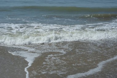 Beyaz köpüklü doğal deniz dalgaları Coxs Bazar, Bangladeş 'te kumlu sahilde süzülüyor. Seyahat, yaz, doğa, deniz yaşamı, kıyı geçmişi ve rahatlama kavramları için mükemmel..