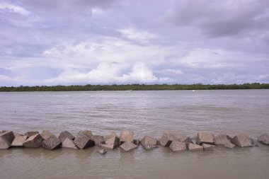 Coxs Bazar yakınlarındaki Bakkhali Nehri 'nin sakin gelgit sularını, balıkçı teknelerini ve uzak mangrovları gösteren huzurlu bir manzarası. Nehir Chittagong Arakan tepelerinden yükselir ve Maheshkhali Kanalı 'na akar..