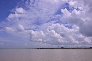 Görkemli mavi gökyüzü ve kabarık bulutları olan tropik nehir arka planı. Yaz tatilleri, ilham verici sosyal medya paylaşımları ya da mutlu yeni yıl tasarımları için mükemmel bir doğa manzarası..