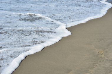 Turkuaz deniz suyu ile Laboni Sahili 'ndeki altın kum arasındaki sınırın soyut bir bileşimi, Bangladeş' teki Cox 's Bazar deniz plajının imzalı bir manzarası..
