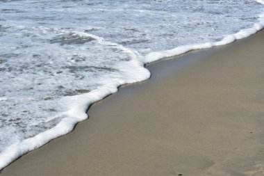 Turkuaz deniz suyu ile Laboni Sahili 'ndeki altın kum arasındaki sınırın soyut bir bileşimi, Bangladeş' teki Cox 's Bazar deniz plajının imzalı bir manzarası..