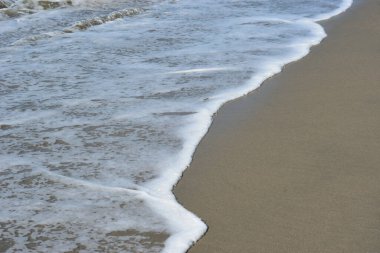 Turkuaz deniz suyu ile Laboni Sahili 'ndeki altın kum arasındaki sınırın soyut bir bileşimi, Bangladeş' teki Cox 's Bazar deniz plajının imzalı bir manzarası..