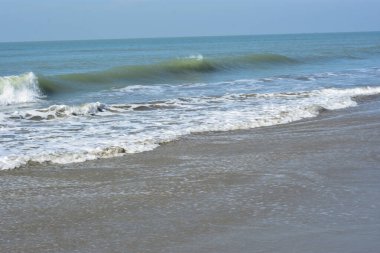 Sakin ve sakin deniz suyu Laboni Sahili 'nin düz kumları üzerinde yavaşça akıyor, parlak gökyüzünü ve Cox' s Bazar sahil şeridinin gezginler ve turistler için huzurlu doğasını yansıtıyor..