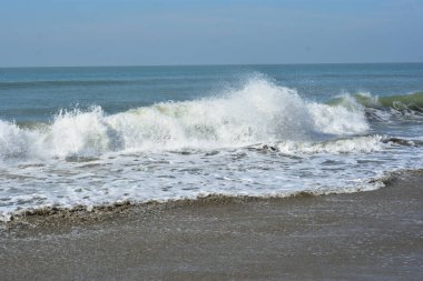 Sakin ve sakin deniz suyu Laboni Sahili 'nin düz kumları üzerinde yavaşça akıyor, parlak gökyüzünü ve Cox' s Bazar sahil şeridinin gezginler ve turistler için huzurlu doğasını yansıtıyor..