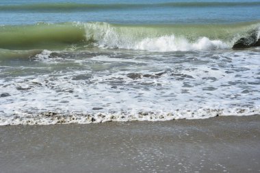 Sakin ve sakin deniz suyu Laboni Sahili 'nin düz kumları üzerinde yavaşça akıyor, parlak gökyüzünü ve Cox' s Bazar sahil şeridinin gezginler ve turistler için huzurlu doğasını yansıtıyor..