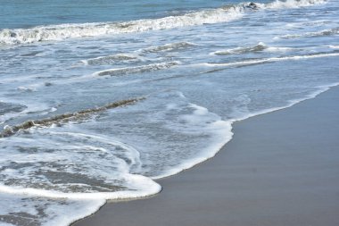 Sakin ve sakin deniz suyu Laboni Sahili 'nin düz kumları üzerinde yavaşça akıyor, parlak gökyüzünü ve Cox' s Bazar sahil şeridinin gezginler ve turistler için huzurlu doğasını yansıtıyor..