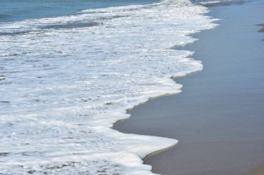 Laboni Sahili 'ndeki altın kumla çarpışan bir dalganın eşsiz çapraz perspektifi, Bangladeş' teki Cox 's Bazar turist merkezinde denizin dinamik enerjisini vurguluyor..