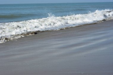 Laboni Sahili 'ndeki altın kumla çarpışan bir dalganın eşsiz çapraz perspektifi, Bangladeş' teki Cox 's Bazar turist merkezinde denizin dinamik enerjisini vurguluyor..