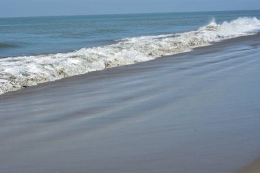 Laboni Sahili 'ndeki altın kumla çarpışan bir dalganın eşsiz çapraz perspektifi, Bangladeş' teki Cox 's Bazar turist merkezinde denizin dinamik enerjisini vurguluyor..
