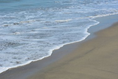 Laboni Sahili 'ndeki altın kumla çarpışan bir dalganın eşsiz çapraz perspektifi, Bangladeş' teki Cox 's Bazar turist merkezinde denizin dinamik enerjisini vurguluyor..