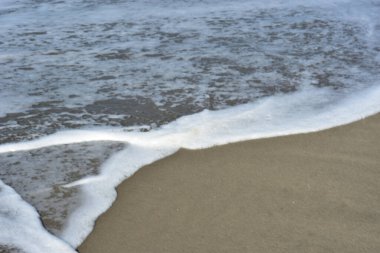 Yumuşak deniz köpüğü ve beyaz kabarcıklar, Cox 's Bazar' da popüler bir turizm beldesi olan Laboni Sahili 'nin ıslak kıyılarında parıldıyor. Canlı atmosferi ve çarpıcı Bengal Körfezi manzaralarıyla tanınıyor..