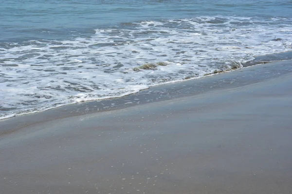 Turkuaz deniz suyu ile Laboni Sahili 'ndeki altın kum arasındaki sınırın soyut bir bileşimi, Bangladeş' teki Cox 's Bazar deniz plajının imzalı bir manzarası..