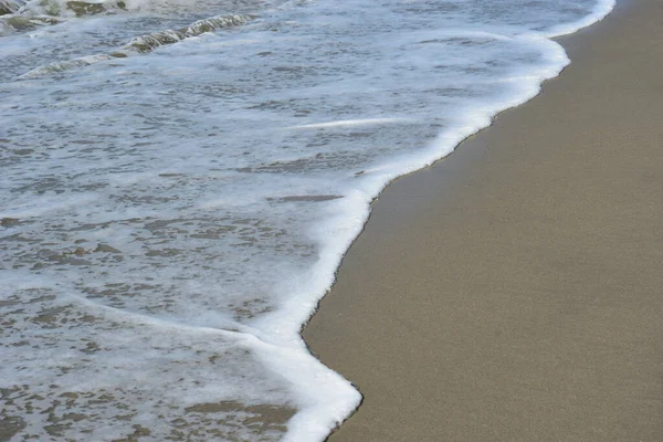 Turkuaz deniz suyu ile Laboni Sahili 'ndeki altın kum arasındaki sınırın soyut bir bileşimi, Bangladeş' teki Cox 's Bazar deniz plajının imzalı bir manzarası..