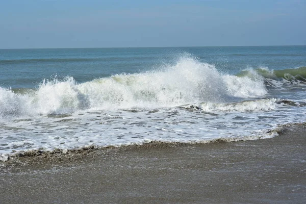 Sakin ve sakin deniz suyu Laboni Sahili 'nin düz kumları üzerinde yavaşça akıyor, parlak gökyüzünü ve Cox' s Bazar sahil şeridinin gezginler ve turistler için huzurlu doğasını yansıtıyor..