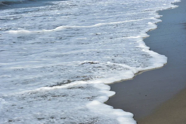 Sakin ve sakin deniz suyu Laboni Sahili 'nin düz kumları üzerinde yavaşça akıyor, parlak gökyüzünü ve Cox' s Bazar sahil şeridinin gezginler ve turistler için huzurlu doğasını yansıtıyor..