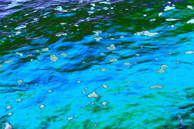 Mavi ve yeşil yansıtıcı sıvı bir yüzey, yüzen ışık vurguları ve organik dokusu var. Doğa, bilim, çevre, dijital sanat ve tasarım kullanımı için yüksek çözünürlüklü arka plan ideali.