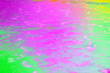 Dinamik neon renkli su yüzeyi, akıcı sıvı dalgalanmaları, parlak yansımaları ve canlı gökkuşağı eğimleriyle. Modern arka planlar, dijital sanat, posterler ve yaratıcı markalaşma projeleri için mükemmel..