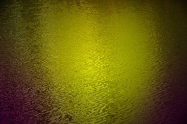 Su yüzeyindeki renkli yağ darbelerinin soyut arkaplanı.