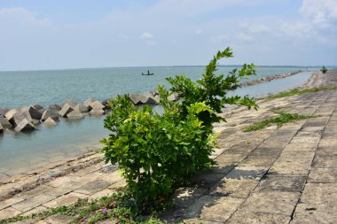Coxs Bazar 'daki Bakkhali Nehri seti sakin su, beton yürüyüş yolu ve açık gökyüzü, huzurlu sahil kıyısı sahnesi