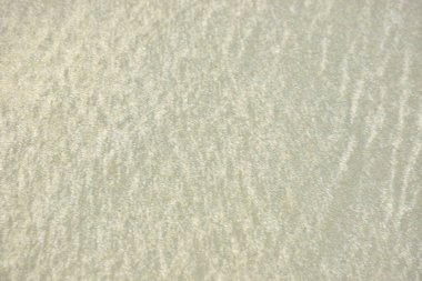 Rüzgâr ve sığ suların oluşturduğu doğal kum dalgalanmaları plaj yüzeyinde soyut desenler oluşturur. Tasarım ve doğa kavramları için ideal minimum kıyı arkaplanı, ince ışık ve organik kumlu detaylar.