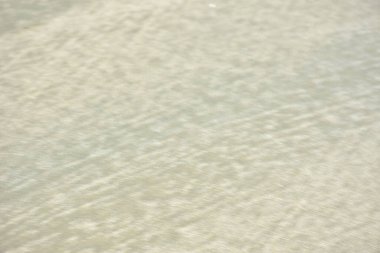 Rüzgâr ve sığ suların oluşturduğu doğal kum dalgalanmaları plaj yüzeyinde soyut desenler oluşturur. Tasarım ve doğa kavramları için ideal minimum kıyı arkaplanı, ince ışık ve organik kumlu detaylar.