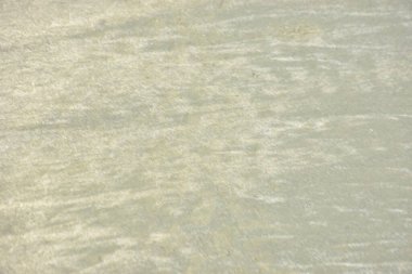 Rüzgâr ve sığ suların oluşturduğu doğal kum dalgalanmaları plaj yüzeyinde soyut desenler oluşturur. Tasarım ve doğa kavramları için ideal minimum kıyı arkaplanı, ince ışık ve organik kumlu detaylar.