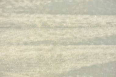 Rüzgâr ve sığ suların oluşturduğu doğal kum dalgalanmaları plaj yüzeyinde soyut desenler oluşturur. Tasarım ve doğa kavramları için ideal minimum kıyı arkaplanı, ince ışık ve organik kumlu detaylar.