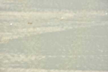 Rüzgâr ve sığ suların oluşturduğu doğal kum dalgalanmaları plaj yüzeyinde soyut desenler oluşturur. Tasarım ve doğa kavramları için ideal minimum kıyı arkaplanı, ince ışık ve organik kumlu detaylar.