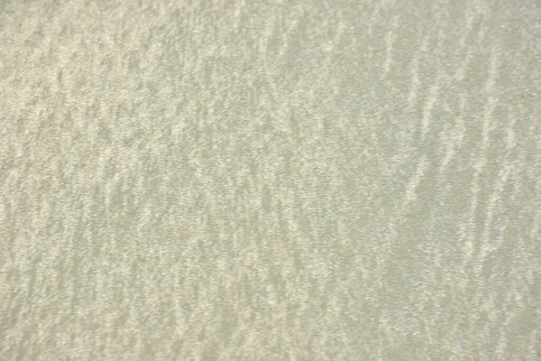 Rüzgâr ve sığ suların oluşturduğu doğal kum dalgalanmaları plaj yüzeyinde soyut desenler oluşturur. Tasarım ve doğa kavramları için ideal minimum kıyı arkaplanı, ince ışık ve organik kumlu detaylar.