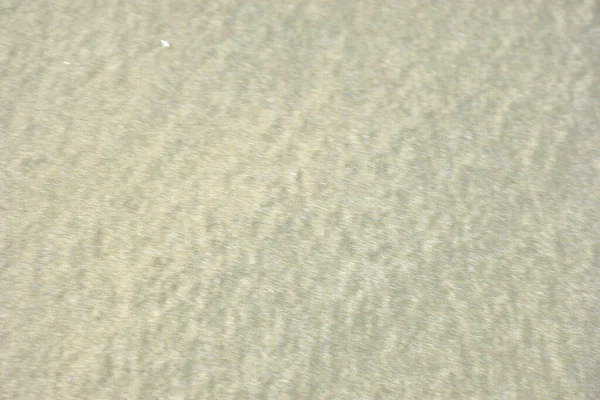 Rüzgâr ve sığ suların oluşturduğu doğal kum dalgalanmaları plaj yüzeyinde soyut desenler oluşturur. Tasarım ve doğa kavramları için ideal minimum kıyı arkaplanı, ince ışık ve organik kumlu detaylar.