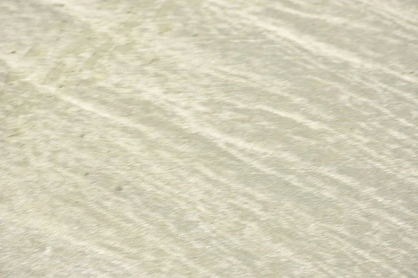 Rüzgâr ve sığ suların oluşturduğu doğal kum dalgalanmaları plaj yüzeyinde soyut desenler oluşturur. Tasarım ve doğa kavramları için ideal minimum kıyı arkaplanı, ince ışık ve organik kumlu detaylar.