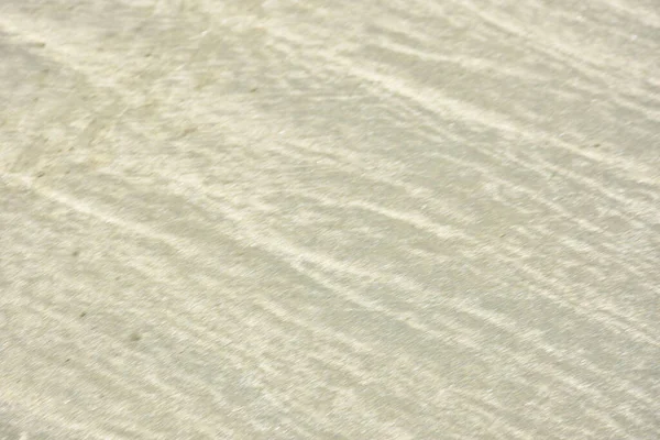 Rüzgâr ve sığ suların oluşturduğu doğal kum dalgalanmaları plaj yüzeyinde soyut desenler oluşturur. Tasarım ve doğa kavramları için ideal minimum kıyı arkaplanı, ince ışık ve organik kumlu detaylar.