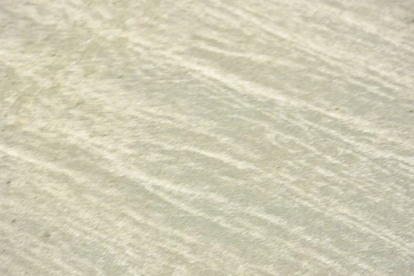 Rüzgâr ve sığ suların oluşturduğu doğal kum dalgalanmaları plaj yüzeyinde soyut desenler oluşturur. Tasarım ve doğa kavramları için ideal minimum kıyı arkaplanı, ince ışık ve organik kumlu detaylar.