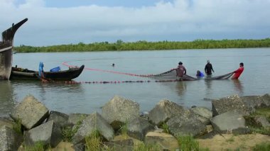 Bir grup balıkçı, Bangladeş 'in Coxs Bazar semtindeki Bakkhali Nehri' nde büyük bir barikat kuruyor. Sular yükseldiğinde geleneksel nehir balıkçılığı faaliyetleri, kırsal geçim kaynaklarını ve Güney Asya kıyı bölgesinde küçük ölçekli balıkçılık uygulamalarını gösteriyor.
