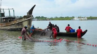 Bir grup balıkçı, Bangladeş 'in Coxs Bazar semtindeki Bakkhali Nehri' nde büyük bir barikat kuruyor. Sular yükseldiğinde geleneksel nehir balıkçılığı faaliyetleri, kırsal geçim kaynaklarını ve Güney Asya kıyı bölgesinde küçük ölçekli balıkçılık uygulamalarını gösteriyor.