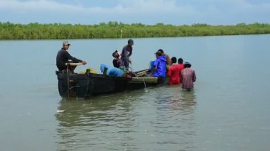Bir grup balıkçı, Bangladeş 'in Coxs Bazar semtindeki Bakkhali Nehri' nde büyük bir barikat kuruyor. Sular yükseldiğinde geleneksel nehir balıkçılığı faaliyetleri, kırsal geçim kaynaklarını ve Güney Asya kıyı bölgesinde küçük ölçekli balıkçılık uygulamalarını gösteriyor.