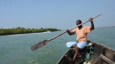 Geleneksel kayıkçı, Bangladeş 'in Chattogram kıyı bölgesinde gelgit mangrov nehri boyunca tahta bir kayıkla kürek çekiyor. Kırsal nehir taşımacılığı ve tropikal mangrov ekosistemindeki günlük yaşam alanı.